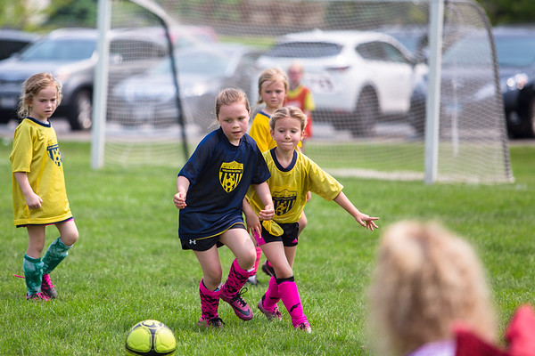 Little girls playing soccer in the field