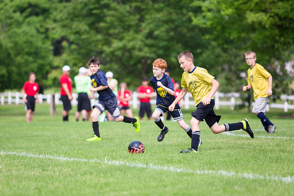 boys are running for the ball in a soccer game